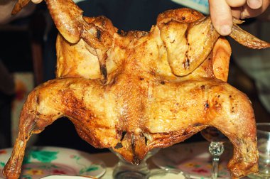 Fırında pişmiş altın ızgara tavuk tabakta yatıyor.