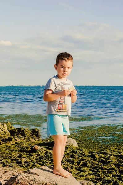 Ragazzo Mangiare Biscotti Sulla Spiaggia — Foto Stock