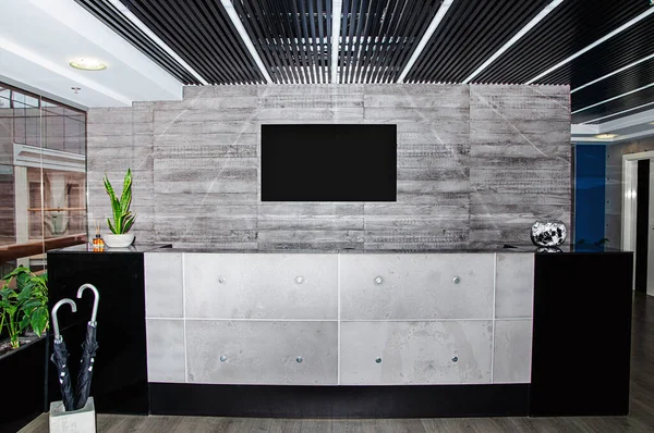 Modern reception area in the office in the style of high-tech. Black umbrellas stand in the stand.