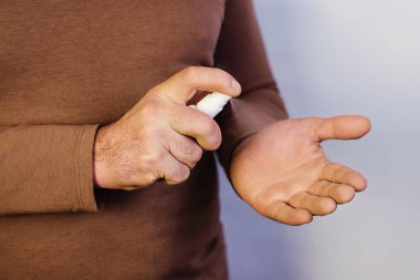 Virüse karşı koruma sağlayan bir adam elleri dezenfekte etmek için sprey kullanır. Epidemia Coronavirus. Covid 19