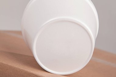 Kapalı beyaz fincanlar izole edilmiş bir arka planda karton bir kutunun üzerinde duruyor..