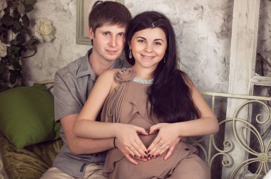 Birbirini seven bir çift hamile, sarılıyor, bebek bekliyor.