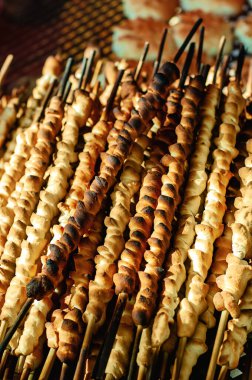 Beyaz ekmek hamuru mangal niyetine şişlerle pişirilir.