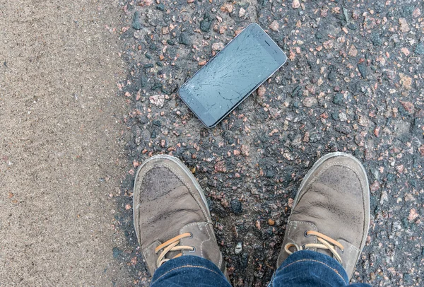 Asfalt üzerinde kırık ekran ile telefon — Stok fotoğraf