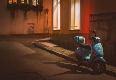 Dar bir sokakta, eski bir şehir sokağında. Scooter kaldırıma park etmiş. Almanya, Bavyera, Avrupa seyahati.