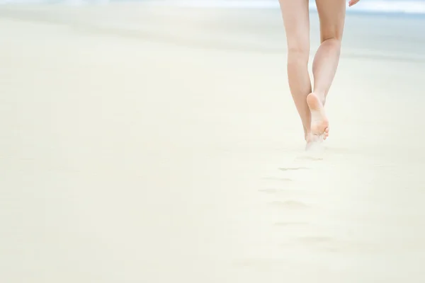 Slim girl in white swimsuit walking to ocean. — Stock Photo, Image