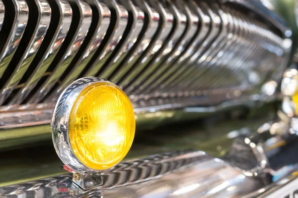 Yellow head light of retro car and radiator grille. — Stock Photo, Image