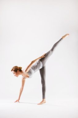 Beyaz arka plan üzerinde yoga yaparken oldukça sportif sarışın