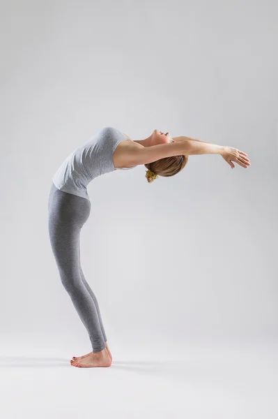 Gri studio arka plan üzerinde yoga yaparken güzel genç kadın — Stok fotoğraf