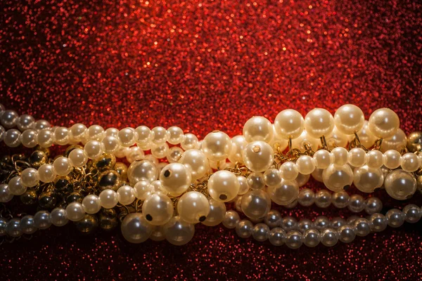 Close up of white pearls on a red glitter background. — Stock Photo, Image