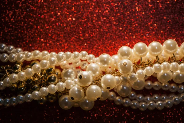 Nær opp av hvite perler på rød glitterbakgrunn . – stockfoto