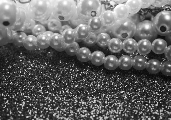 Close up of white pearls on a red glitter background.