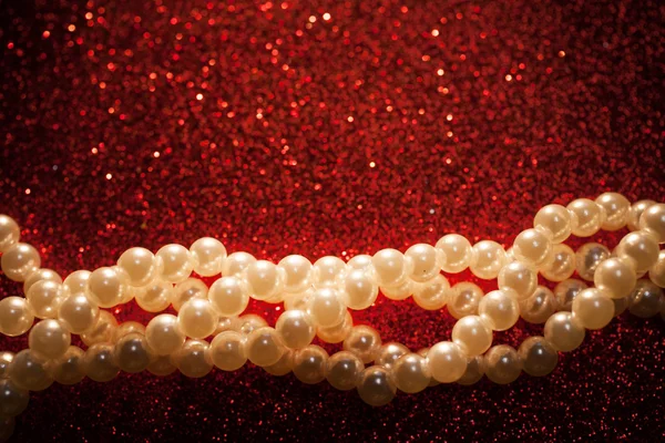 Close up of white pearls on a red glitter background. — Stock Photo, Image