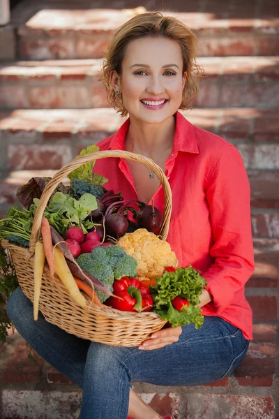 Nutricionista sorridente segurando cesta cheia de legumes ao ar livre. Estilo de vida saudável . — Fotografia de Stock