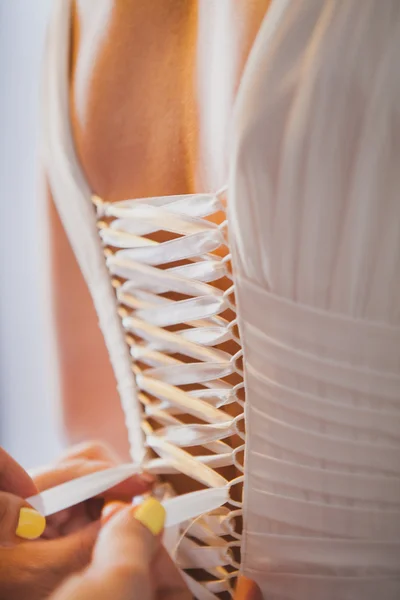 Att hjälpa bruden att sätta sin brudklänning på — Stockfoto