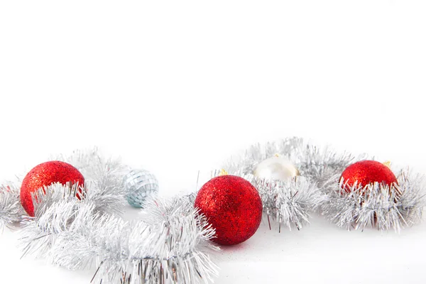 Red balls on silver tinsel. Isolated over white. — Stock Photo, Image