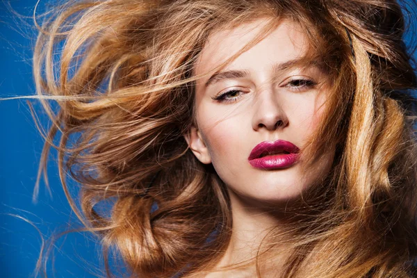 Bellissimo modello di moda con magnifici capelli su sfondo blu — Foto Stock