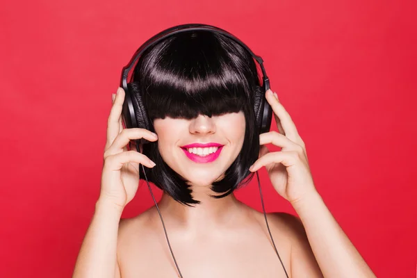 Woman listening to music on headphones enjoying a dance. Closeup portrait of beautiful girl with pink lips — Stock Photo, Image