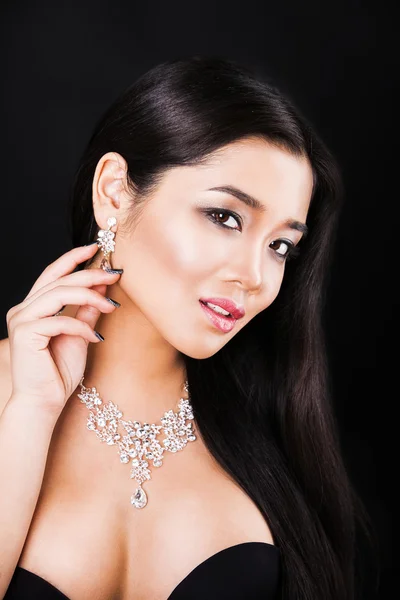 Close up portrait of a beautiful asian brunette model with luxury accessories. on black background — Stock Photo, Image