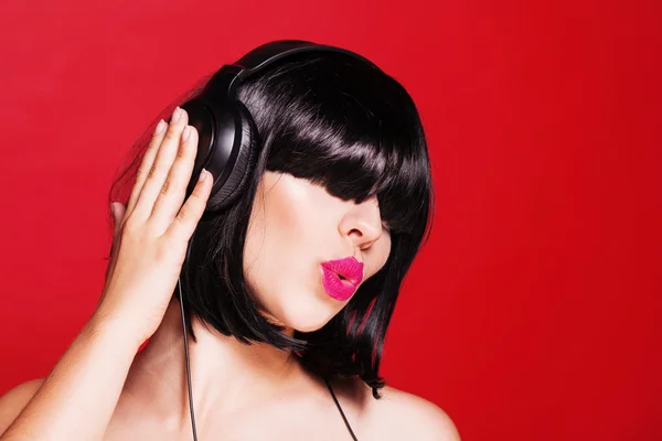 Dj mujer escuchando música en auriculares disfrutando de un baile. Primer plano retrato de hermosa chica con labios rosados — Foto de Stock