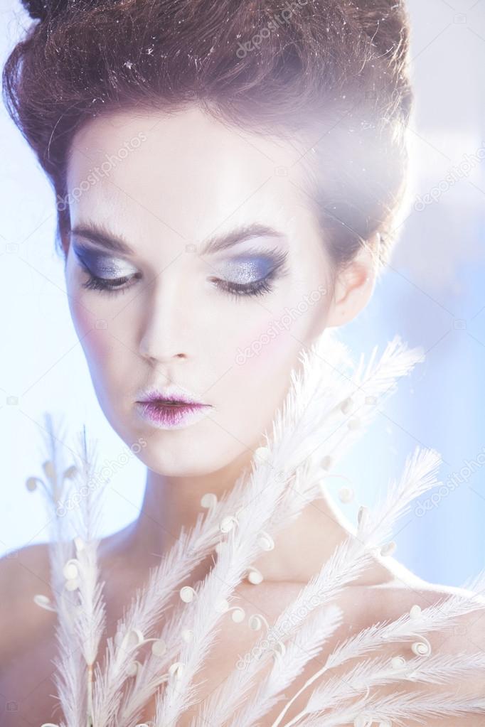 Beauty woman over blue winter background. Winter beauty woman. Snow queen. Make-up