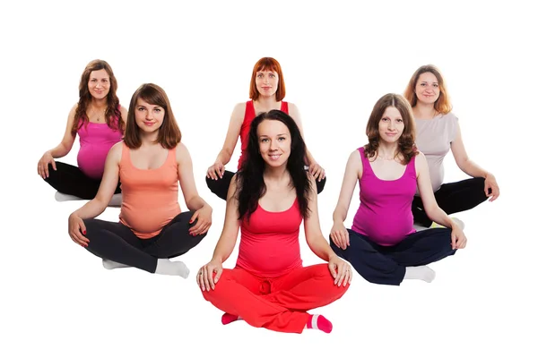 Grupo de mulheres grávidas sorridentes sentadas no chão e praticando Yoga — Fotografia de Stock