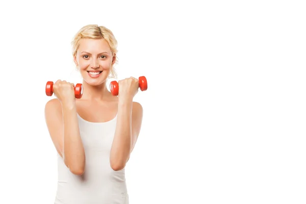 Mujer atlética sonriente bombeando músculos con mancuernas sobre fondo blanco — Foto de Stock