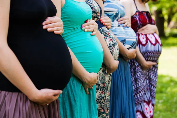 Gros plan du ventre de la femme enceinte du groupe. Femmes enceintes en plein air — Photo