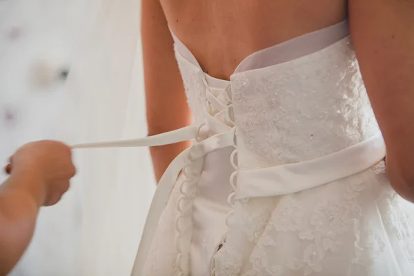 Aiutare la sposa a mettere il suo abito da sposa. Dettagli matrimonio — Foto Stock