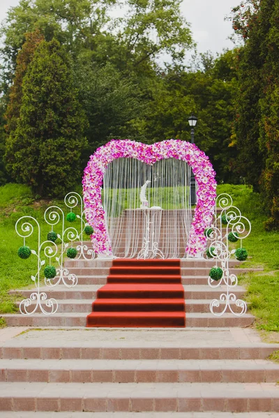 Wedding arch with pink orchid standing on the steps of — Stock Photo, Image