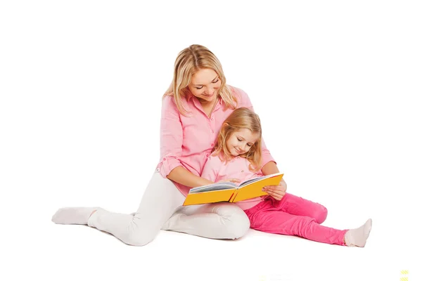 Madre e figlia felici che leggono un libro insieme. Isolato su bianco Immagini Stock Royalty Free