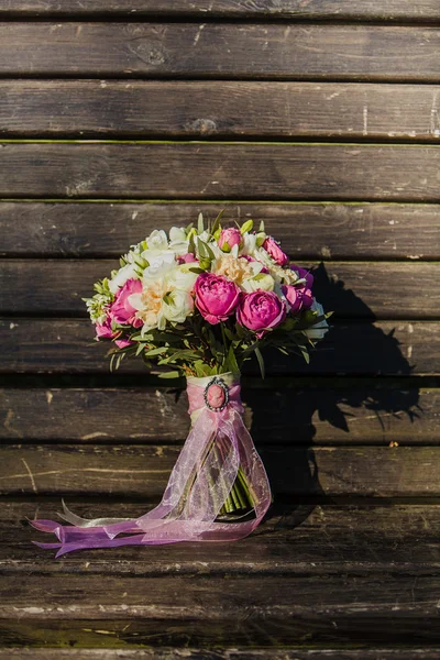Ramo de boda con una cinta rosa en la superficie de madera —  Fotos de Stock