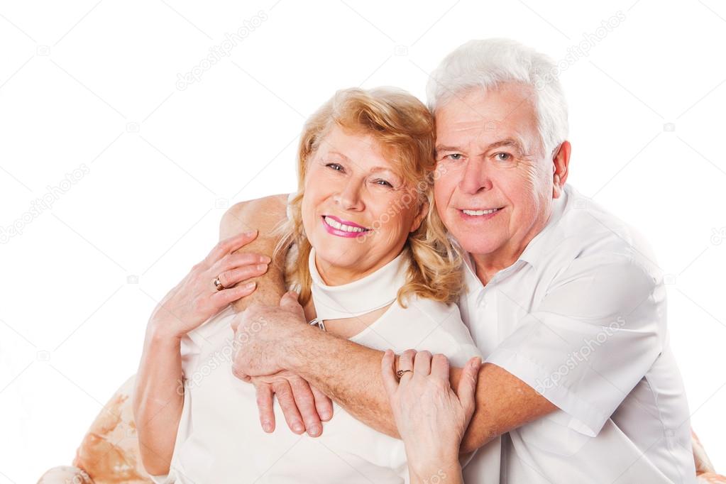 Happy mature senior couple embracing smiling at camera on white background
