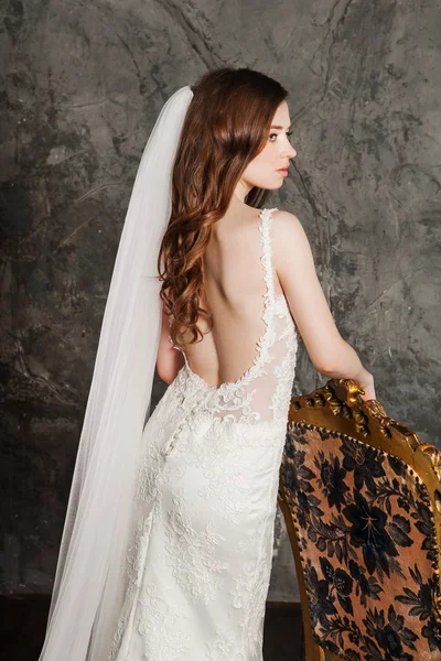 Visão traseira da bela mulher posando em um vestido de noiva elegante — Fotografia de Stock