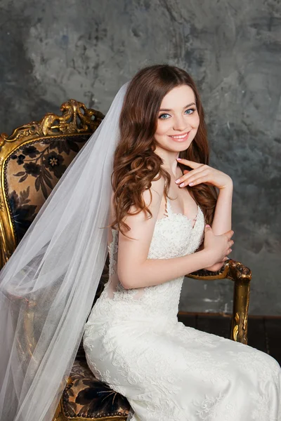Фото красивої усміхненої щасливої нареченої в розкішній весільній сукні в елегантний дорогий інтер'єр — стокове фото
