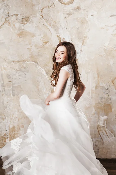 Mooie lachende bruid met perfecte make-up en haarkleur stijl in elegante trouwjurk — Stockfoto