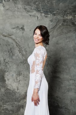 Zarif iç mükemmel makyaj ve saç stili ile gülümseyen güzel esmer gelin