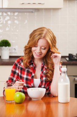 bir kase mısır gevreği süt ile onun kahvaltı için sahip genç güzel kadın