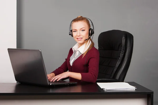 Mujer de negocios hablando por teléfono mientras trabaja en su computadora en la oficina — Foto de Stock