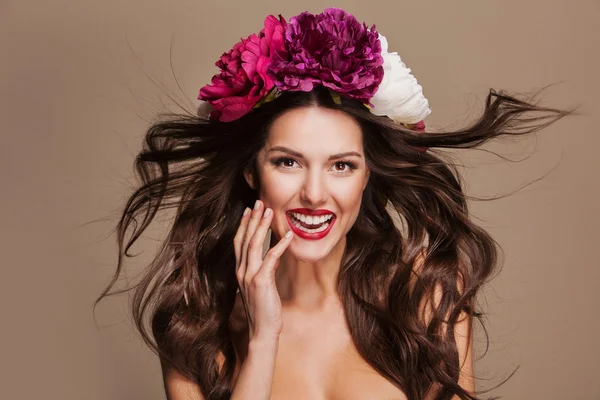 Sexig modell med curle hår och ljusa blommor på hennes huvud — Stockfoto