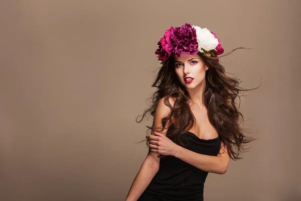 Sexy Model mit lockigem Haar und leuchtenden Blumen auf dem Kopf — Stockfoto