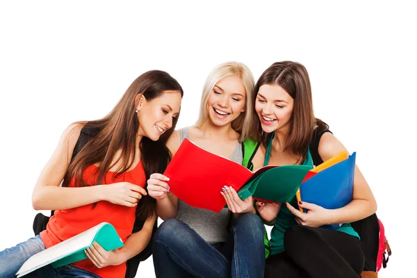 Estudantes, amigos sentados juntos em um fundo branco — Fotografia de Stock