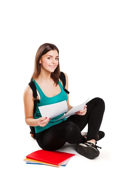 Young teen student sitting on floor with backpack reading a book — Stock Photo, Image