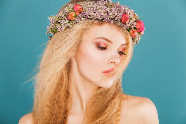 Jeune modèle avec une couronne de fleurs vives sur sa tête — Photo