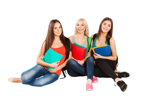 Happy students sitting together with fun, while smiling and looking at camera isolated on white background. — Stock Photo, Image