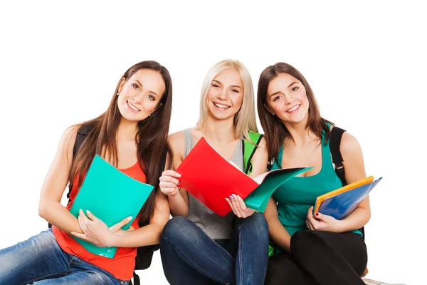 Three happy students sitting together with fun, while smiling and looking at camera isolated on white background. — Stock Photo, Image