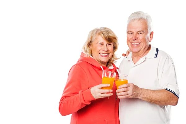Старшая пара со стаканами апельсинового сока на белом фоне . — стоковое фото