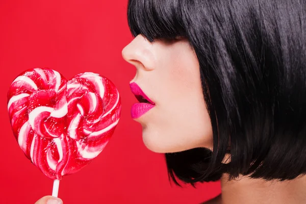 Closeup photo of a beautiful sexy pink lips with lollipop — Stock Photo, Image