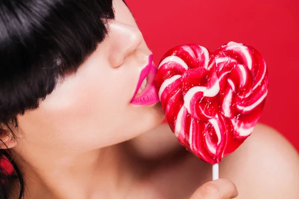 Closeup photo of a beautiful sexy red lips with lollipop Stock Photo