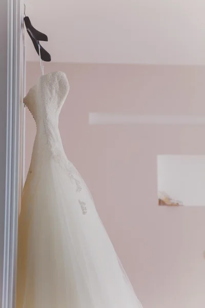 Weißes Hochzeitskleid hängt an den Schultern — Stockfoto